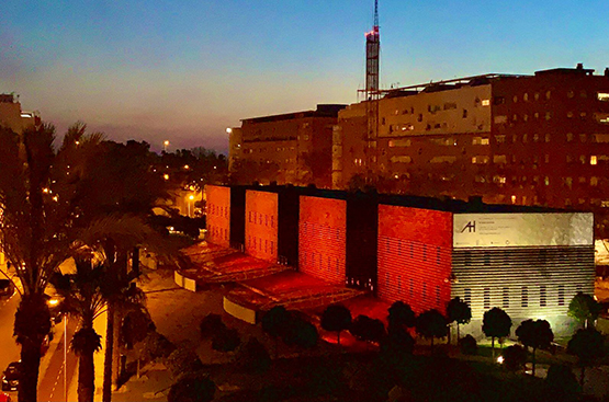 Foto nocturna de sede emhasa iluminada en naranja